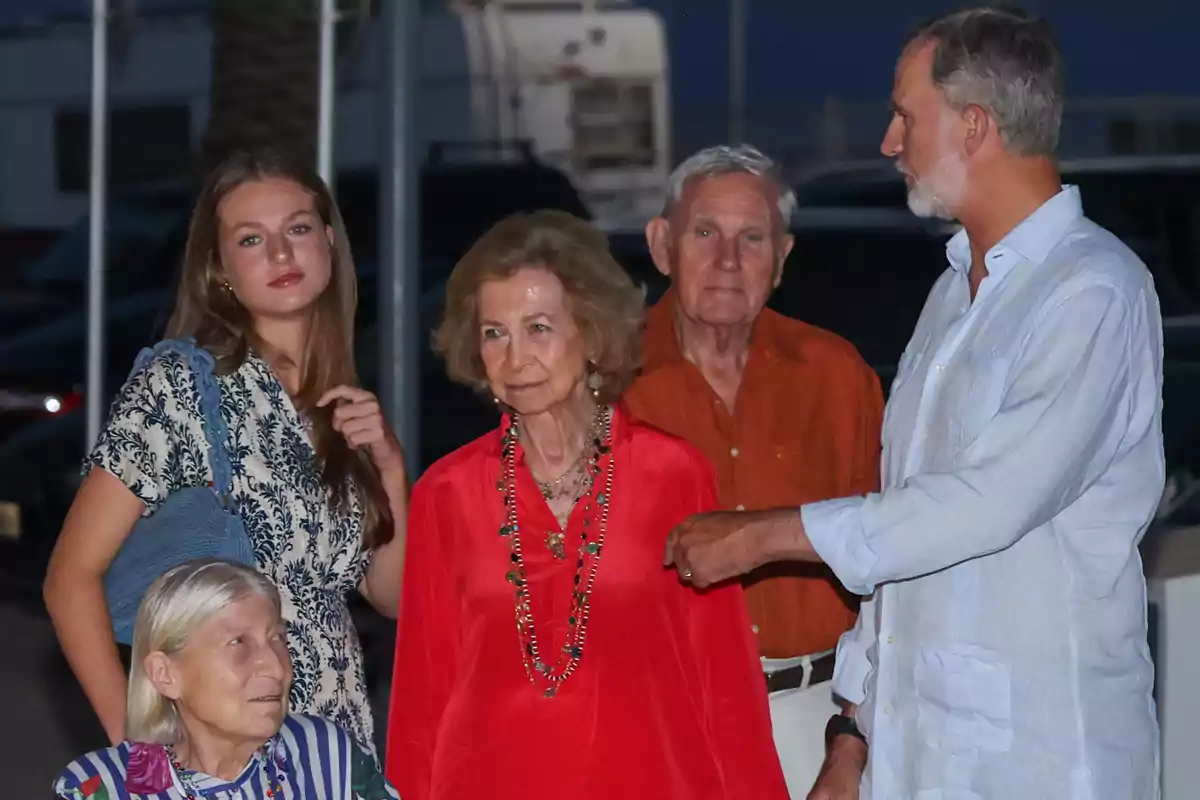 Tatiana Radziwil, la princesa Leonor, la reina Sofia, el doctor Fruchau i Felip VI posen a l’aire lliure durant el capvespre, algunes d’elles conversant i d’altres mirant a la càmera, totes vestides amb roba d’estiu i colors variats. Tatiana Radziwil, la princesa Leonor, la reina Sofia, el doctor Fruchau i Felip VI posen a l’aire lliure durant el capvespre, algunes d’elles conversant i d’altres mirant a la càmera, totes vestides amb roba d’estiu i colors variats.