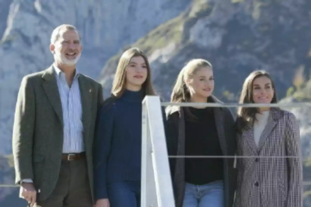Cuatro personas -que son la Familia Real Española- posan juntas al aire libre con montañas de fondo en un día soleado en Asturias. Cuatro personas -que son la Familia Real Española- posan juntas al aire libre con montañas de fondo en un día soleado en Asturias.