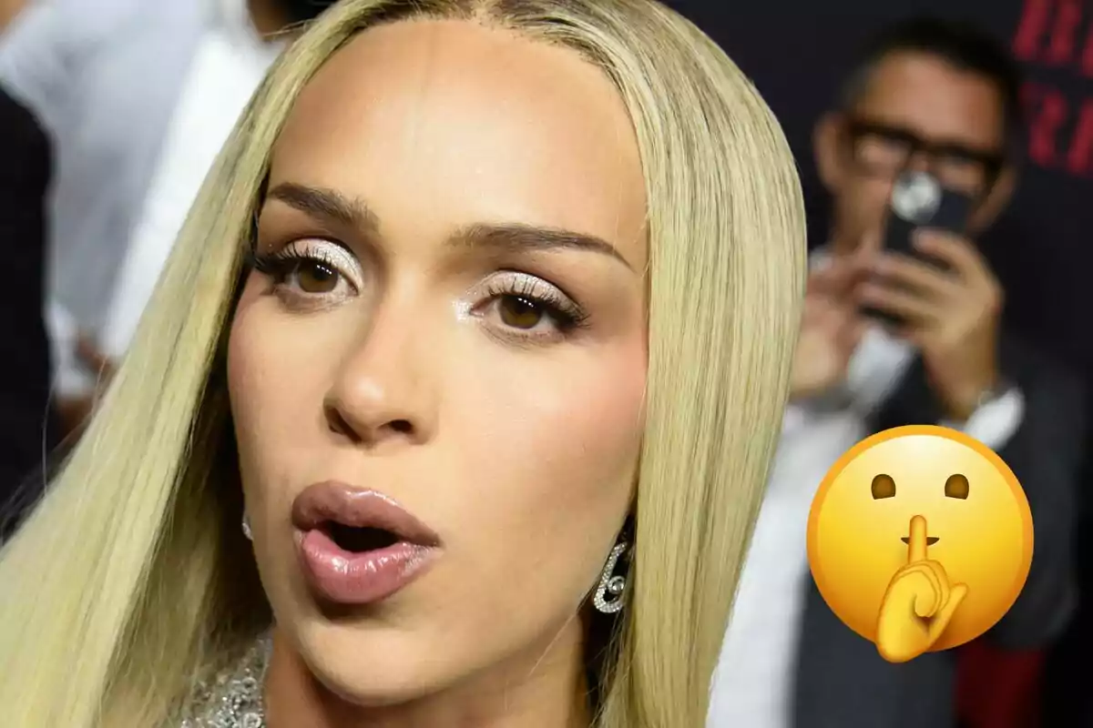 Mujer de cabello rubio lacio con expresión de sorpresa y un emoji de silencio en primer plano