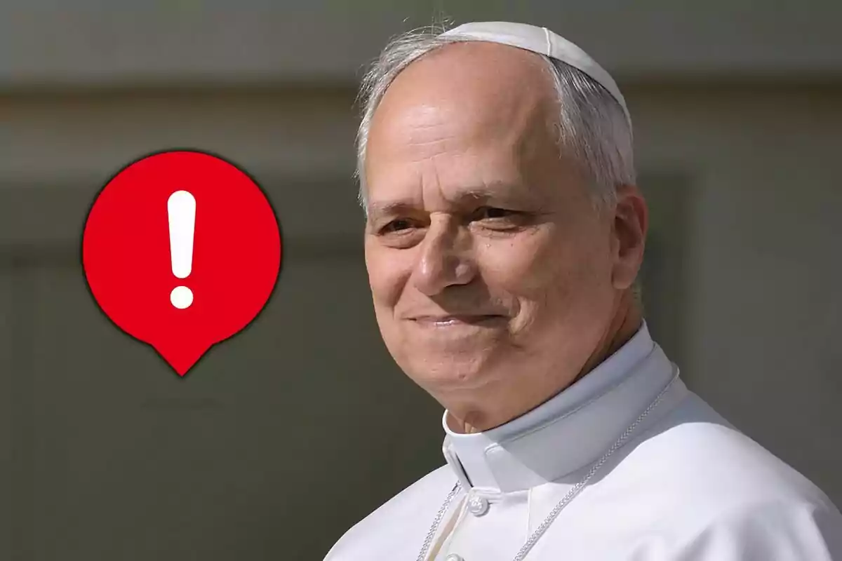 Hombre mayor con vestimenta religiosa blanca y solideo blanco al lado de un ícono rojo con signo de exclamación