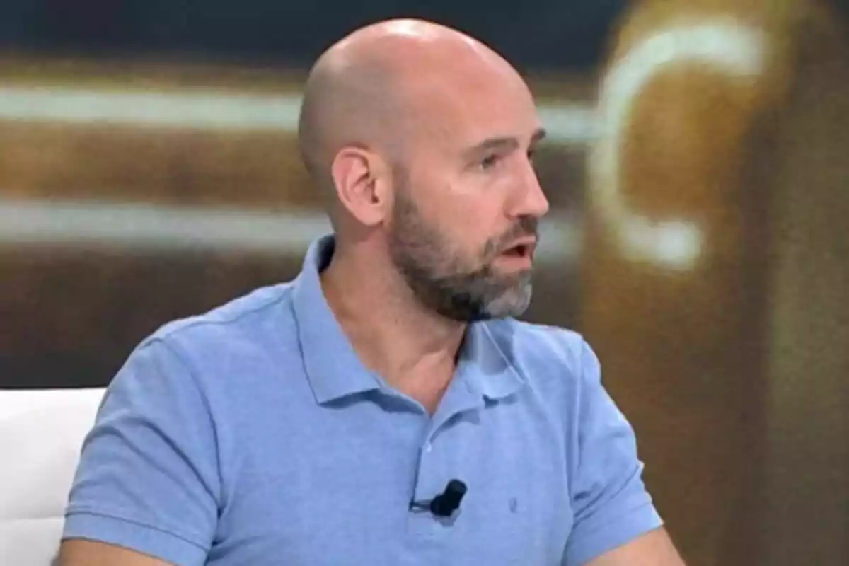 Gonzalo Miró with a beard and a light blue polo jersey speaking in a television studio. Gonzalo Miró with a beard and a light blue polo jersey speaking in a television studio.