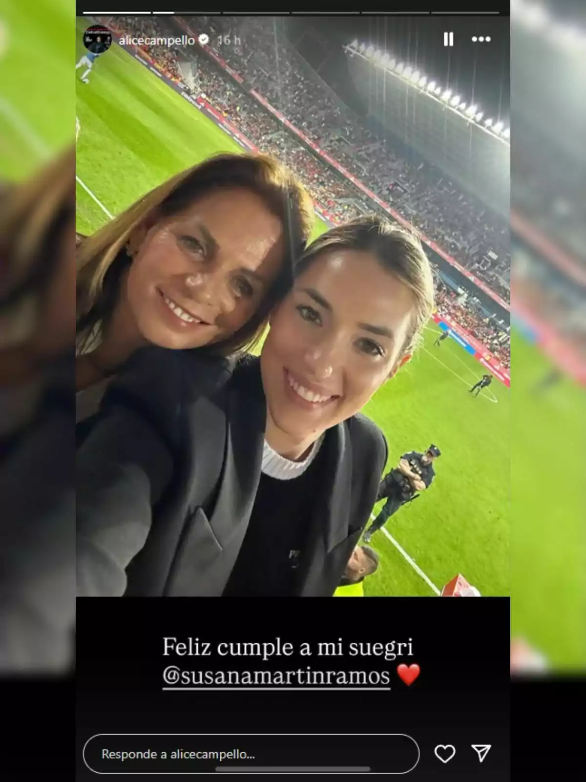 Dues dones somriuen —que són Alice Campello i la seva sogra— i es fan una selfie en un estadi de futbol ple d’espectadors, amb el camp il·luminat al fons i un missatge de felicitació a la part inferior de la imatge. Dues dones somriuen —que són Alice Campello i la seva sogra— i es fan una selfie en un estadi de futbol ple d’espectadors, amb el camp il·luminat al fons i un missatge de felicitació a la part inferior de la imatge.