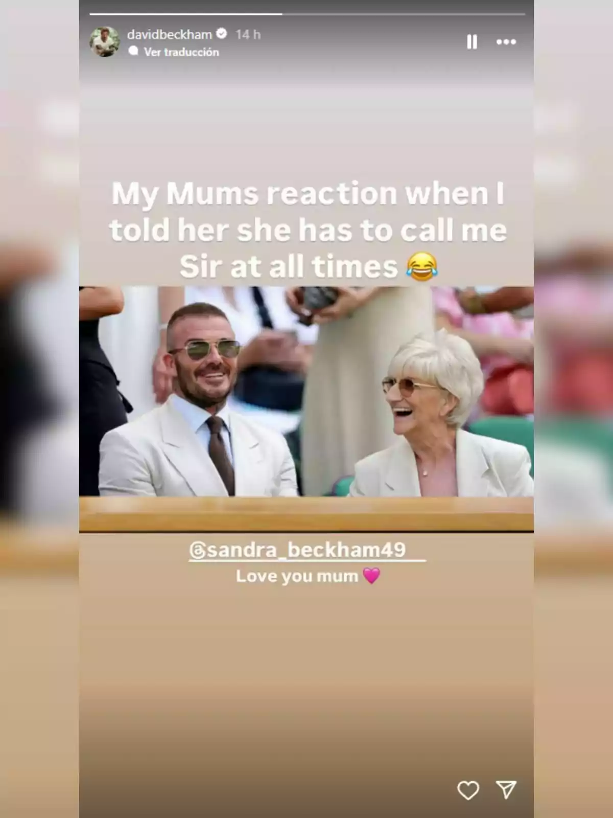 David Beckham and his mother smile and look happy sitting together at an event, both elegantly dressed in light-colored suits. David Beckham and his mother smile and look happy sitting together at an event, both elegantly dressed in light-colored suits.