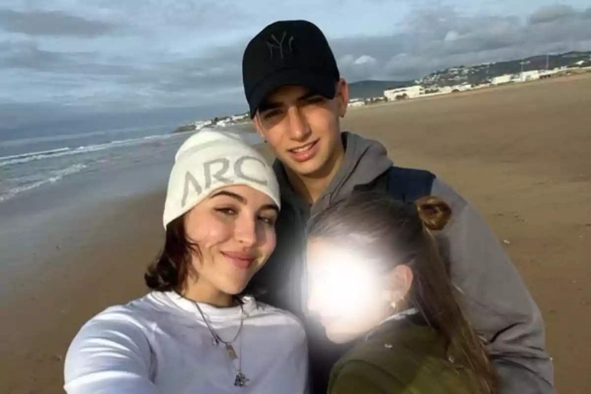 Tres persones posen per a una selfie a la platja, el cel està ennuvolat i la cara d’una d’elles està difuminada. Tres persones posen per a una selfie a la platja, el cel està ennuvolat i la cara d’una d’elles està difuminada.