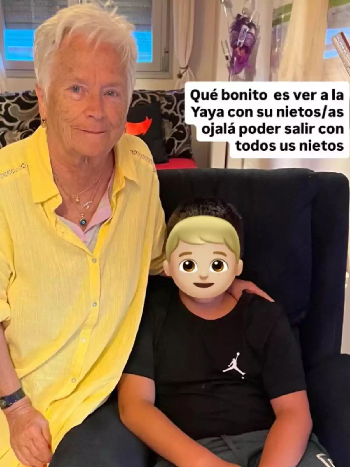 Una senyora gran de cabells blancs i camisa groga està asseguda al costat d’un nen el rostre del qual està cobert amb un emoji, tots dos són en una sala i hi ha un text que parla sobre com és de bonic veure l’àvia amb els seus néts. Una senyora gran de cabells blancs i camisa groga està asseguda al costat d’un nen el rostre del qual està cobert amb un emoji, tots dos són en una sala i hi ha un text que parla sobre com és de bonic veure l’àvia amb els seus néts.
