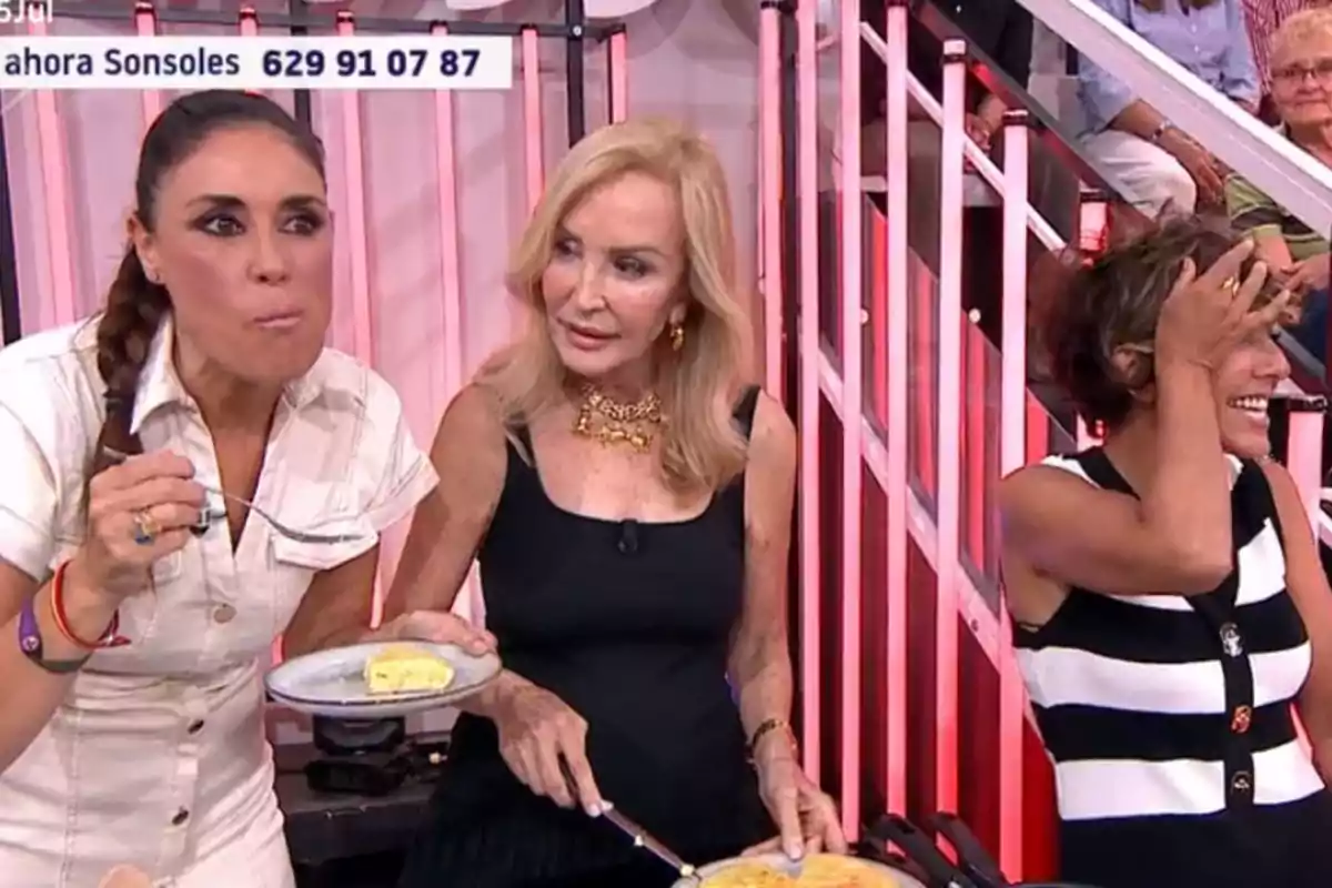 Carmen Lomana, Isabel Rábago y Sonsoles Ónega en un set de televisión, una de ellas come un trozo de tortilla mientras otra sostiene un plato y la tercera se ríe llevándose la mano a la frente Carmen Lomana, Isabel Rábago y Sonsoles Ónega en un set de televisión, una de ellas come un trozo de tortilla mientras otra sostiene un plato y la tercera se ríe llevándose la mano a la frente