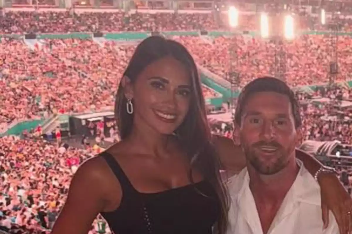 Leo Messi y Antonela Roccuzzo sonríen posando para una foto en un estadio lleno de gente durante un evento. Leo Messi y Antonela Roccuzzo sonríen posando para una foto en un estadio lleno de gente durante un evento.