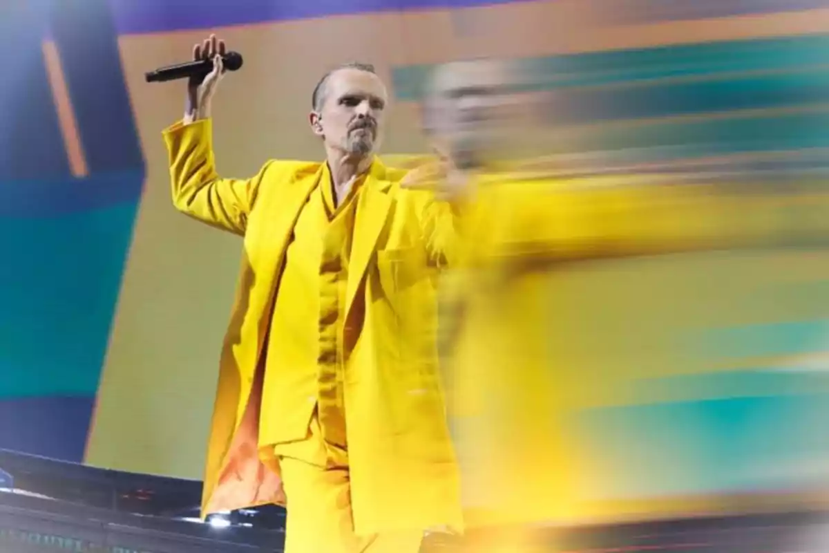Miguel Bosé con traje amarillo cantando en un escenario con fondo colorido y efecto de movimiento Miguel Bosé con traje amarillo cantando en un escenario con fondo colorido y efecto de movimiento