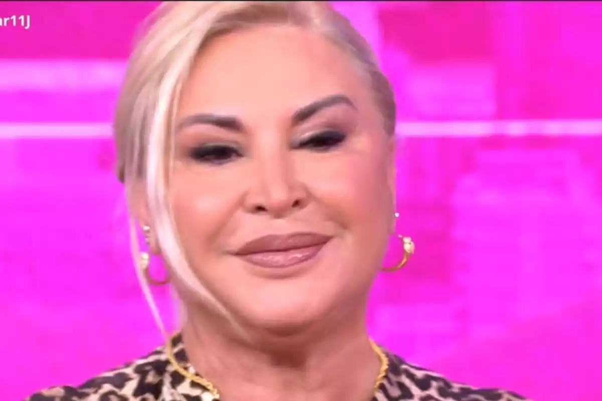 Dona rossa amb maquillatge i arracades daurades sobre fons rosa