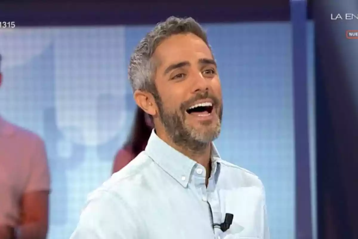 Roberto Leal de cabello corto y barba canosa sonriendo en un set de televisión con camisa clara Roberto Leal de cabello corto y barba canosa sonriendo en un set de televisión con camisa clara