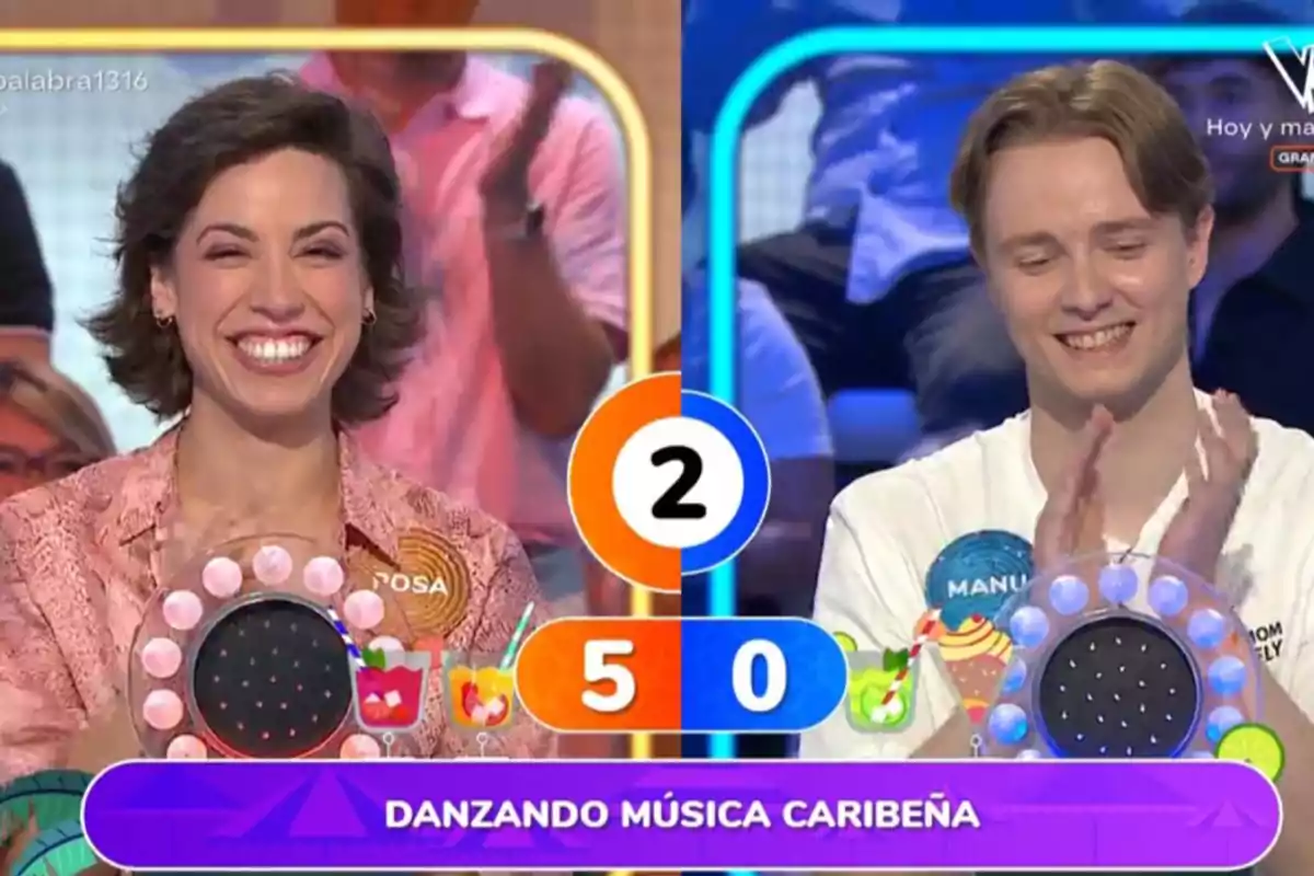 Manu y Rosa sonríen en un programa de televisión de preguntas y respuestas, una mujer a la izquierda y un hombre a la derecha, con un marcador central que muestra el puntaje cinco a cero y la frase danzando música caribeña en la parte inferior Manu y Rosa sonríen en un programa de televisión de preguntas y respuestas, una mujer a la izquierda y un hombre a la derecha, con un marcador central que muestra el puntaje cinco a cero y la frase danzando música caribeña en la parte inferior