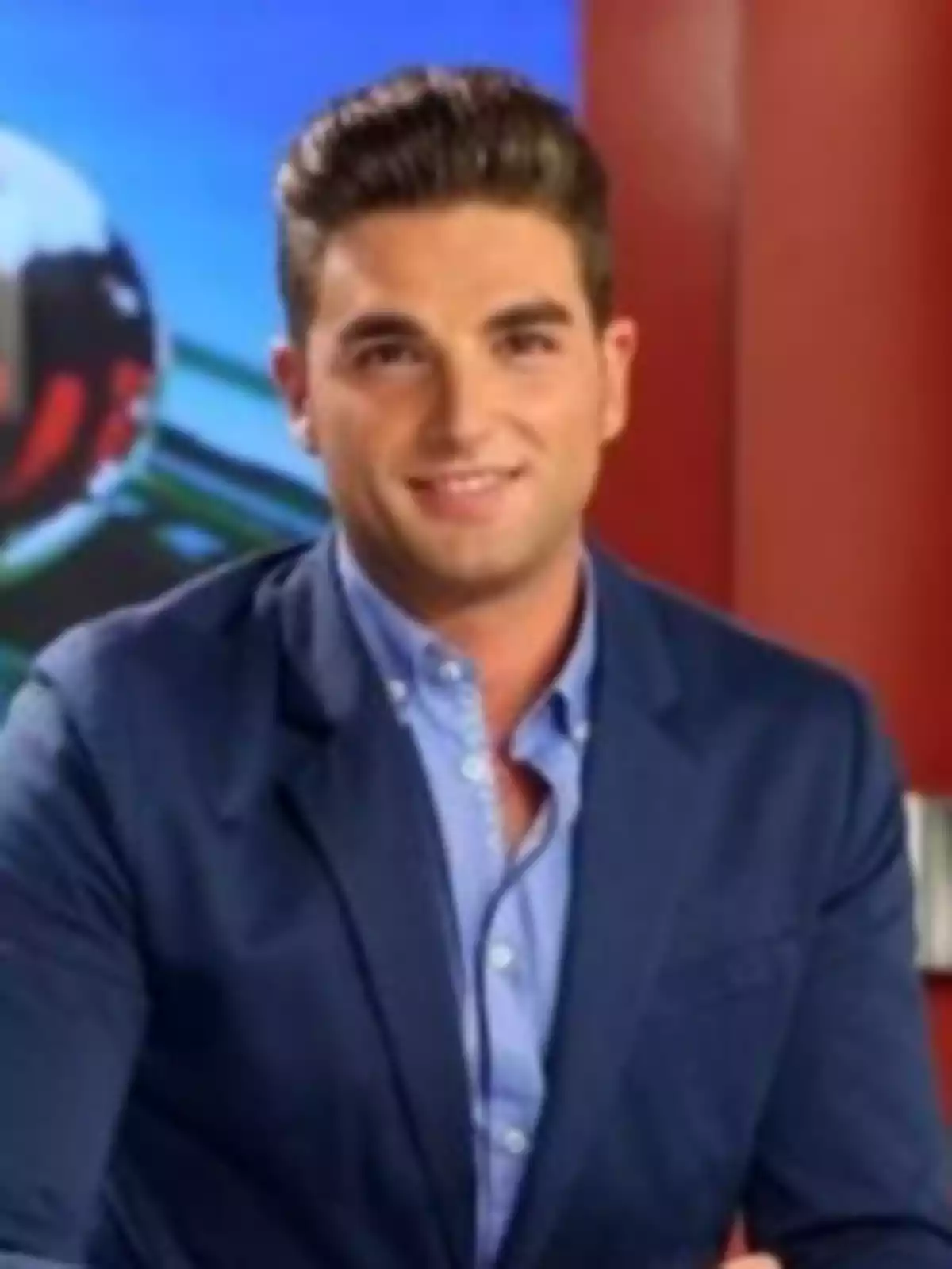 Javi Mardones pentinat cap enrere, vestit amb americana blava i camisa celeste, somrient davant d’un fons acolorit en un estudi de televisió Javi Mardones pentinat cap enrere, vestit amb americana blava i camisa celeste, somrient davant d’un fons acolorit en un estudi de televisió