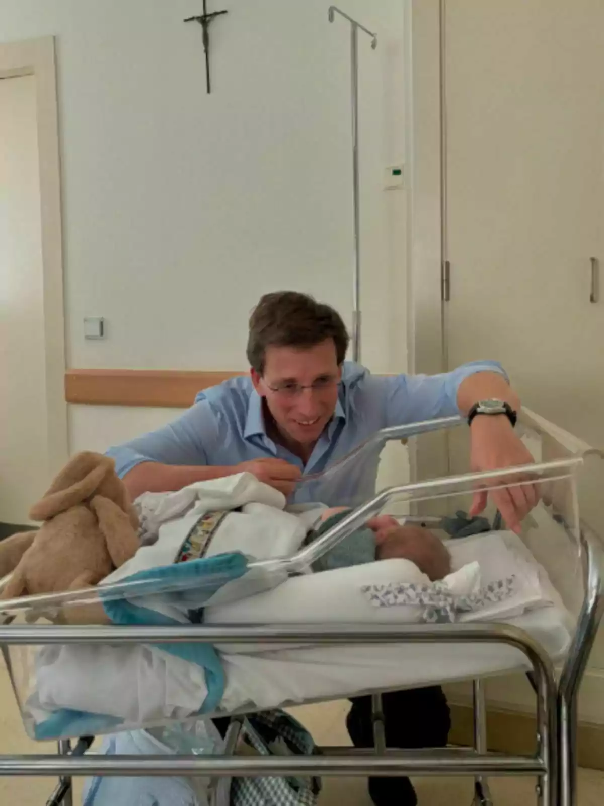 José Luís Martínez Almeida sonriente inclinado sobre una cuna de hospital mirando a un bebé recién nacido. José Luís Martínez Almeida sonriente inclinado sobre una cuna de hospital mirando a un bebé recién nacido.