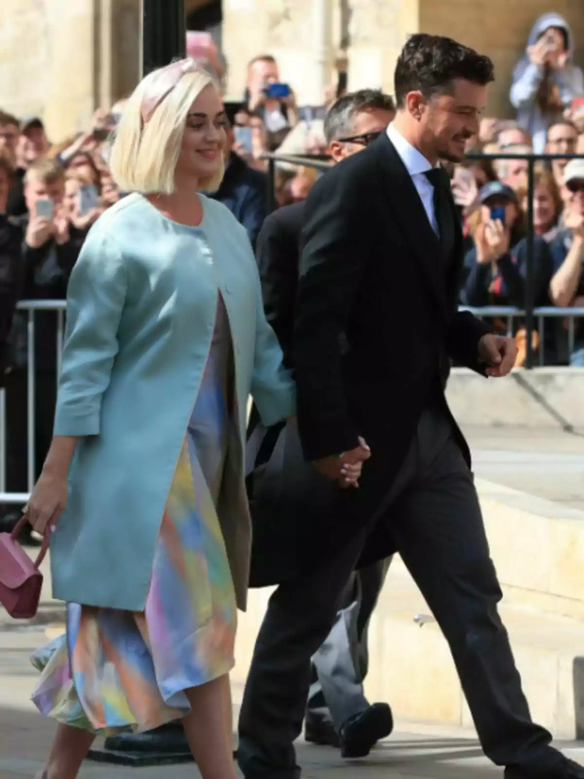 Katy Perry i Orlando Bloom, elegantment vestits, caminant de la mà entre una multitud de persones que fan fotos. Katy Perry i Orlando Bloom, elegantment vestits, caminant de la mà entre una multitud de persones que fan fotos.