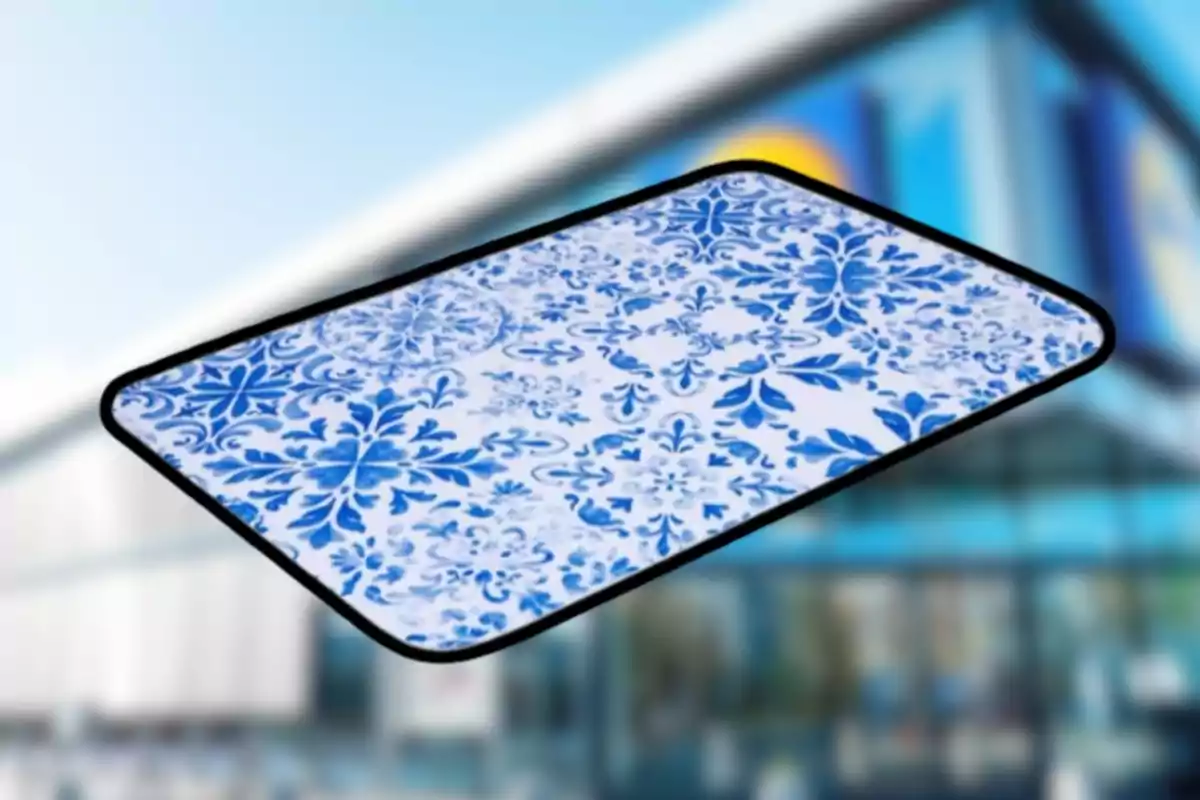 Tapis rectangular amb disseny de flors blaves sobre fons blanc i vora negra davant d’un edifici desenfocat Tapis rectangular amb disseny de flors blaves sobre fons blanc i vora negra davant d’un edifici desenfocat