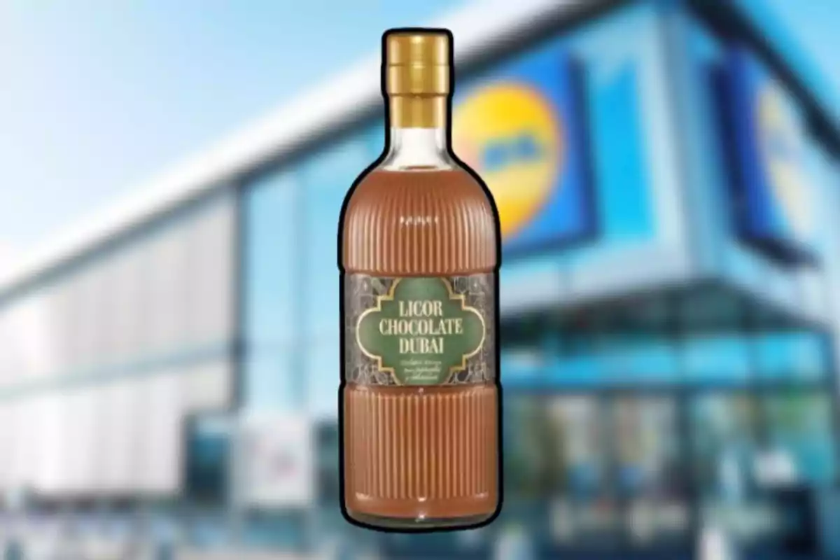 Ampolla de licor de xocolata de Dubai davant d’una botiga amb façana moderna i rètol blau i groc desenfocat. Ampolla de licor de xocolata de Dubai davant d’una botiga amb façana moderna i rètol blau i groc desenfocat.