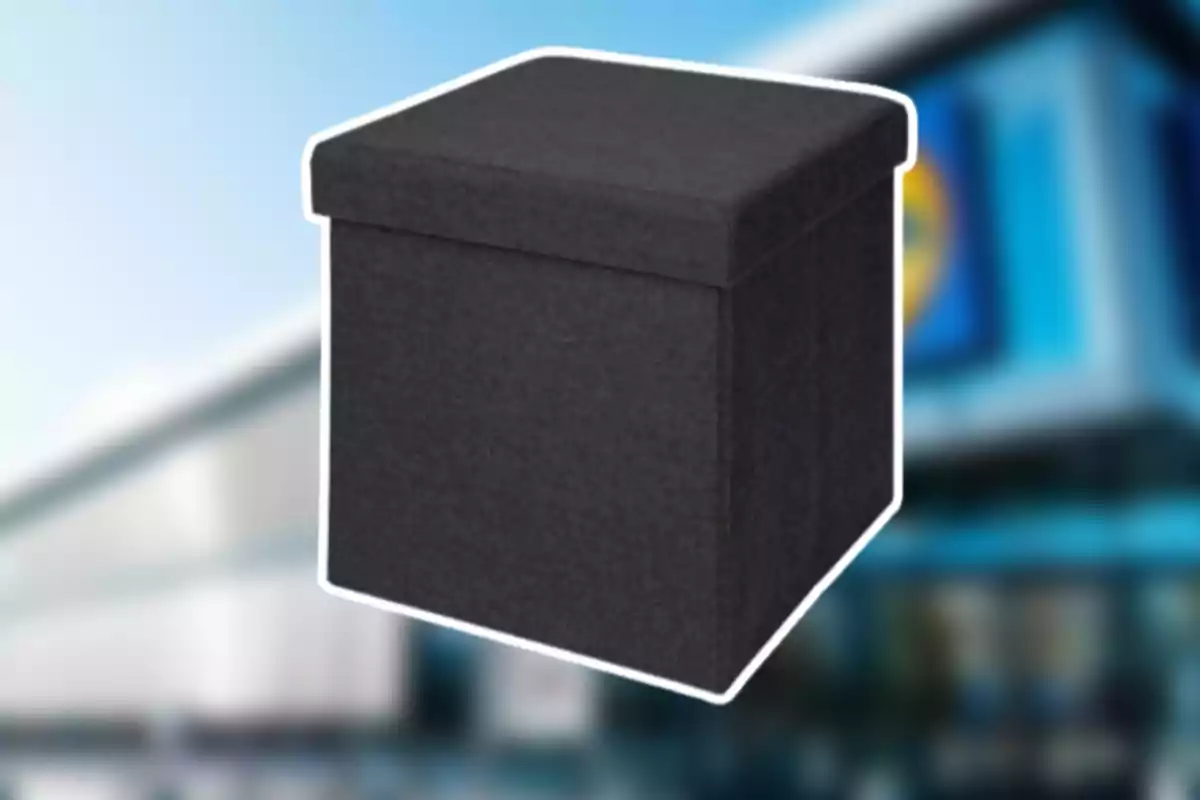 Un puf quadrat de tela de color negre davant d’un fons desenfocat d’una botiga Un puf quadrat de tela de color negre davant d’un fons desenfocat d’una botiga