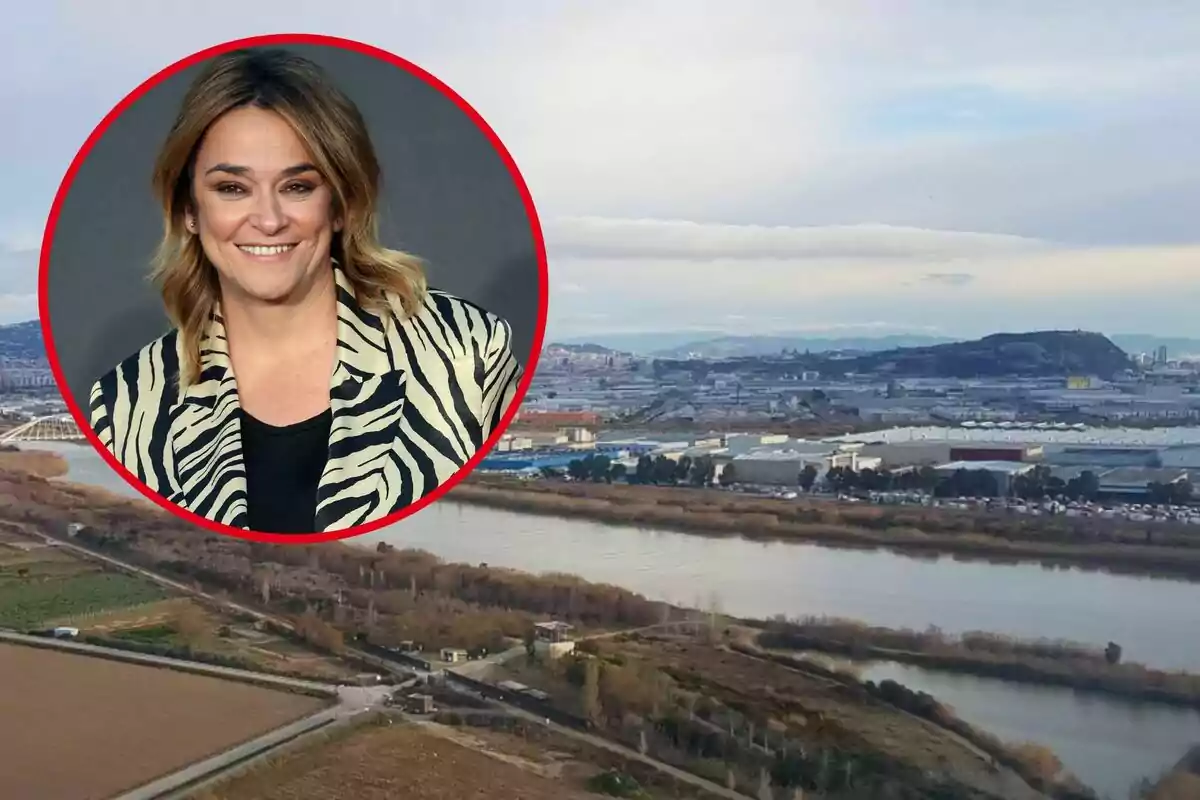 Dona somrient amb jaqueta d’estampat animal en un cercle vermell sobre un paisatge de riu i zona industrial