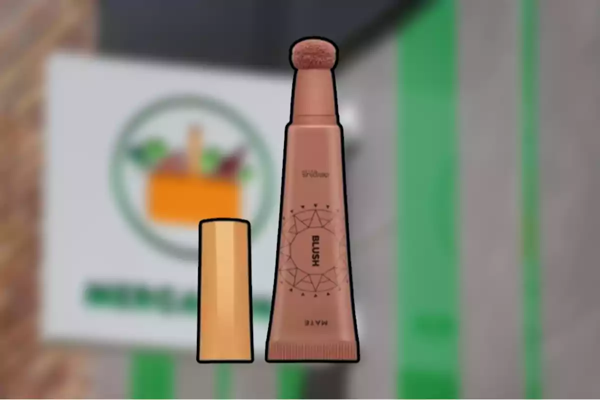 Rubor líquid en un envàs de color marró amb aplicador d’esponja i tapa daurada sobre un fons difuminat de botiga Rubor líquid en un envàs de color marró amb aplicador d’esponja i tapa daurada sobre un fons difuminat de botiga