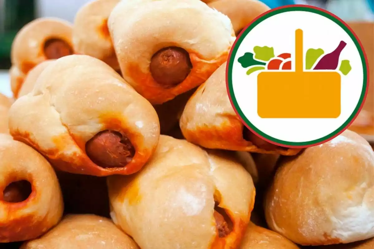 Varios panes rellenos de salchicha apilados junto a un gráfico de canasta con verduras y una botella