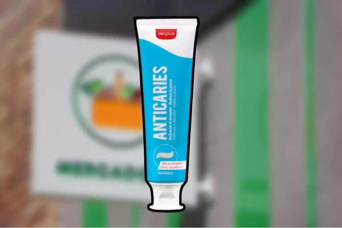 Pasta de dents anticàries de la marca Deliplus davant d’un cartell borros de supermercat Pasta de dents anticàries de la marca Deliplus davant d’un cartell borros de supermercat