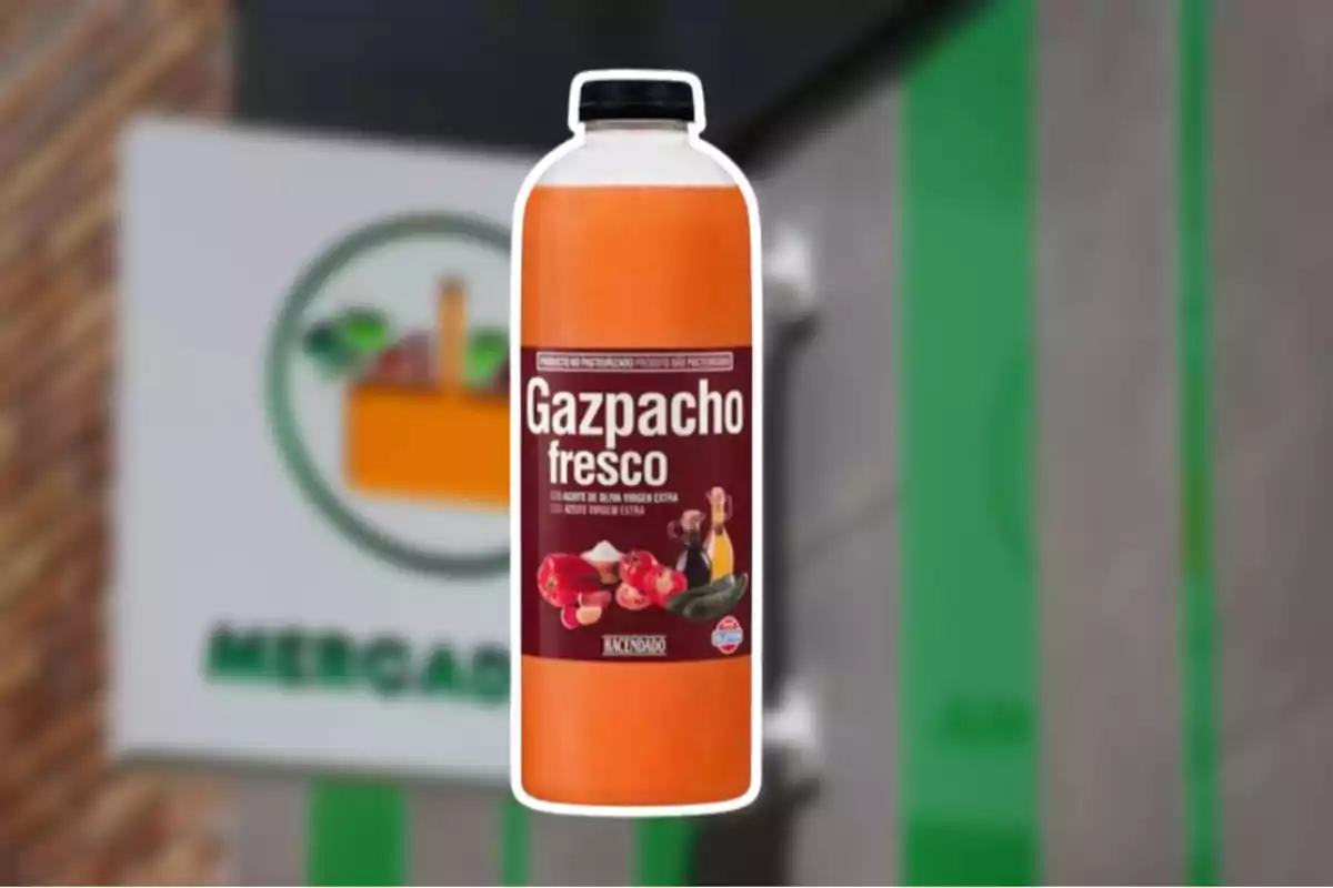 Ampolla de gaspatxo fresc de la marca Hacendado davant d’un cartell de supermercat desenfocat. Ampolla de gaspatxo fresc de la marca Hacendado davant d’un cartell de supermercat desenfocat.