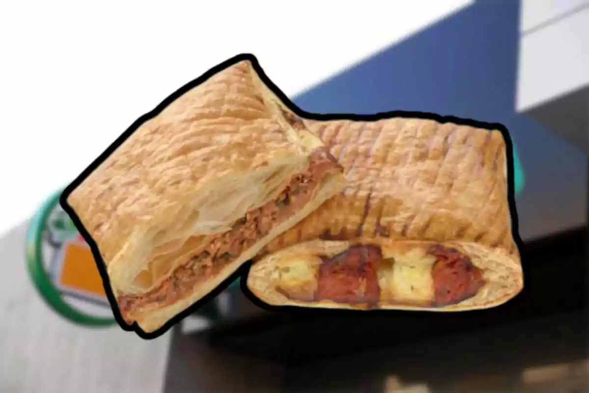 Dues empanades de pasta de full farcides, una de tonyina i una altra de xoriço amb formatge, sobre un fons desenfocat d’una botiga. Dues empanades de pasta de full farcides, una de tonyina i una altra de xoriço amb formatge, sobre un fons desenfocat d’una botiga.