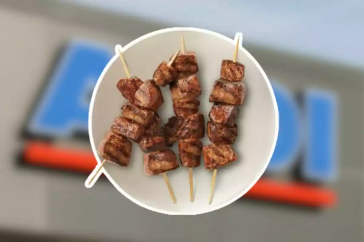 Plato blanco con brochetas de carne asada sobre un fondo desenfocado Plato blanco con brochetas de carne asada sobre un fondo desenfocado