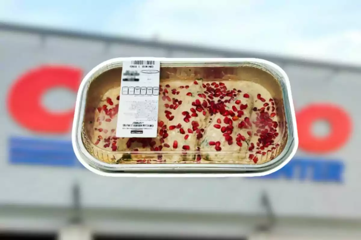 Tray of chiles en nogada with pomegranate on top and a nutrition label on the front, held in front of a blurred Costco store.