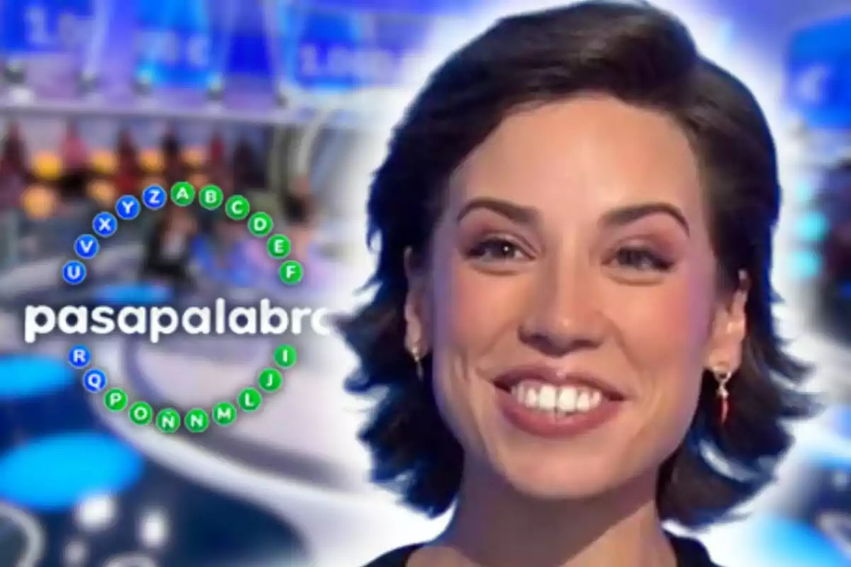Rosa Rodríguez somrient en primer pla amb el logotip del programa 'Pasapalabra' de fons en un plató de televisió.