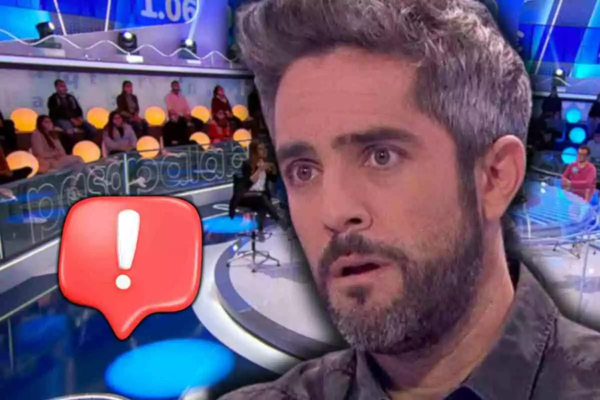 Roberto Leal amb expressió de sorpresa a 'Pasapalabra' amb públic i una icona d’advertència vermella en primer pla