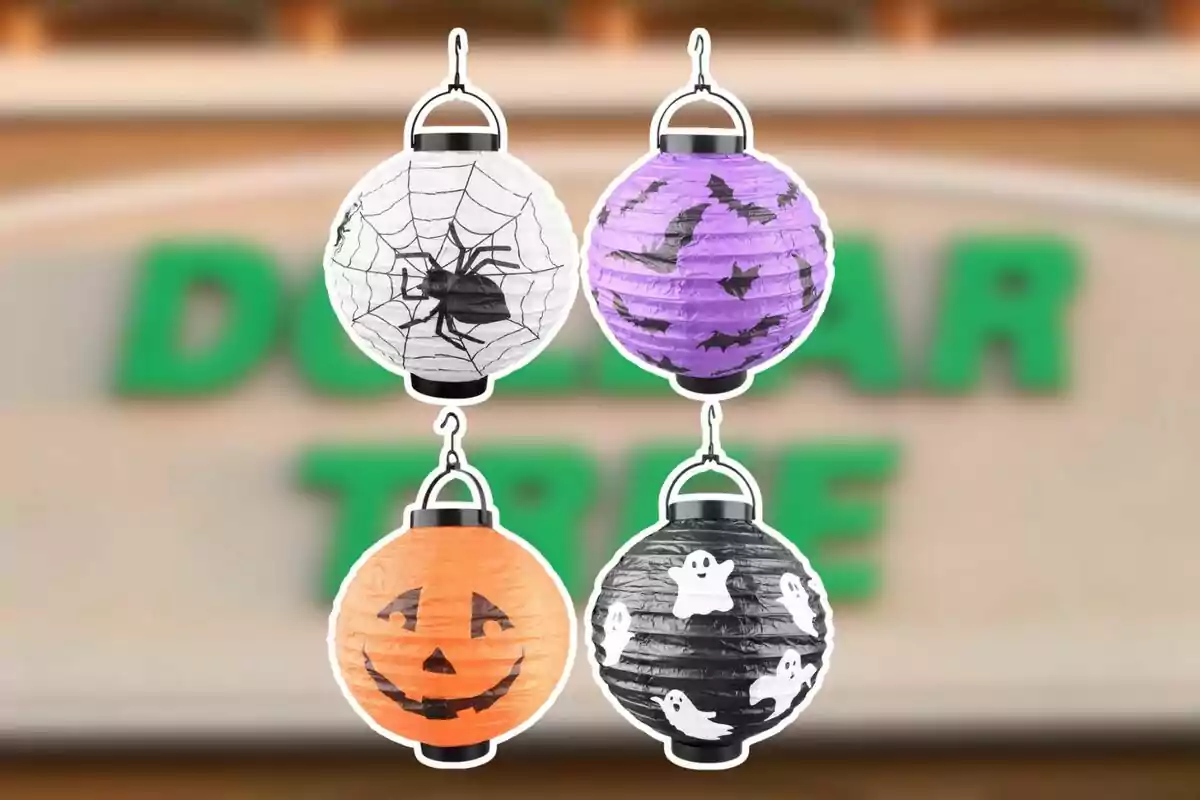 Cuatro farolillos de papel con diseños de Halloween, uno blanco con telaraña y araña, uno morado con murciélagos, uno naranja con cara de calabaza y uno negro con fantasmas, sobre un fondo desenfocado de una tienda.