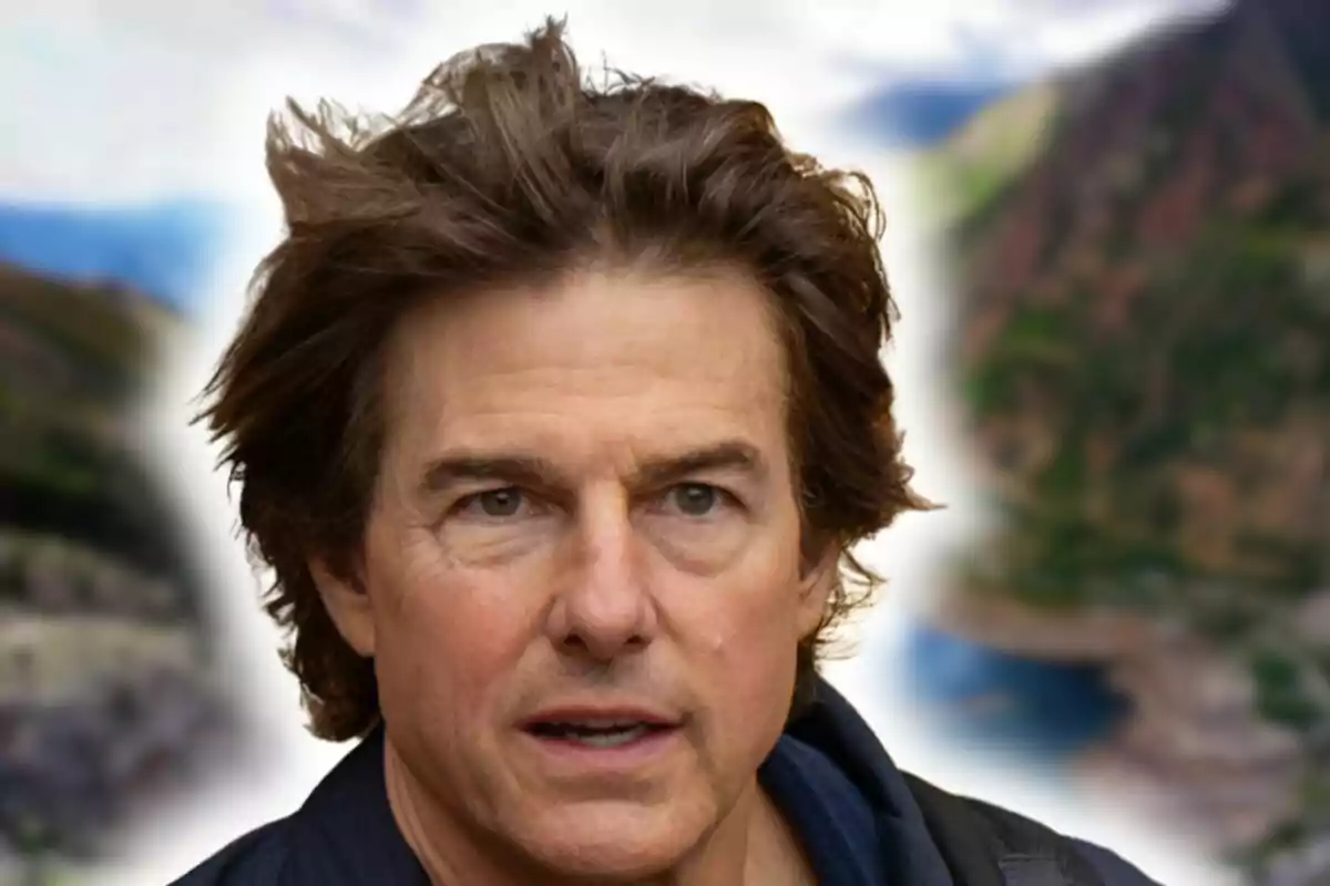 Close-up of Tom Cruise with a serious expression against a blurred background of the Pyrenees landscape.