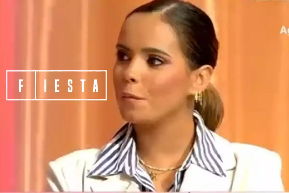 Muntatge de Gloria Camila, molt seriosa i amb jaqueta blanca i camisa de ratlles, al costat del logotip de 'Fiesta'