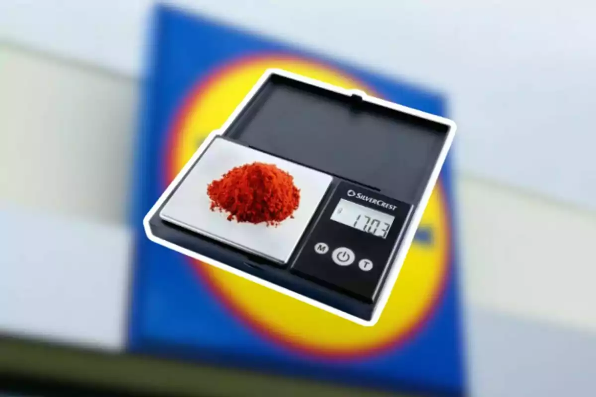 Bàscula digital de precisió amb una petita quantitat de pols vermell sobre el plat i un fons desenfocat d’un rètol de supermercat Bàscula digital de precisió amb una petita quantitat de pols vermell sobre el plat i un fons desenfocat d’un rètol de supermercat