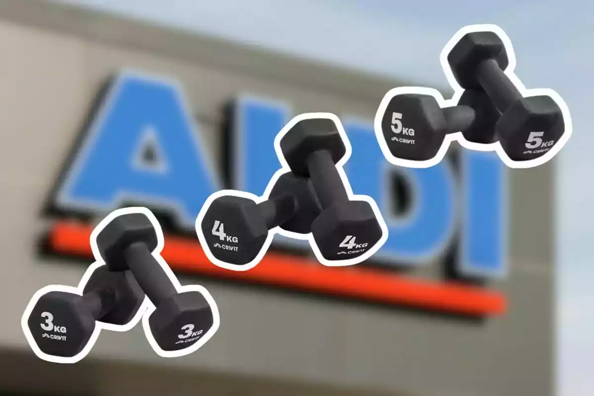 Mancuernas negras de diferentes pesos flotando frente a un letrero borroso de una tienda Aldi Mancuernas negras de diferentes pesos flotando frente a un letrero borroso de una tienda Aldi