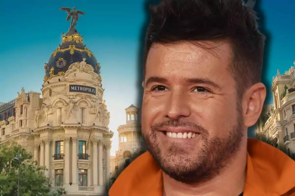 Pablo López sonriente en primer plano con el edificio Metrópolis de Madrid al fondo