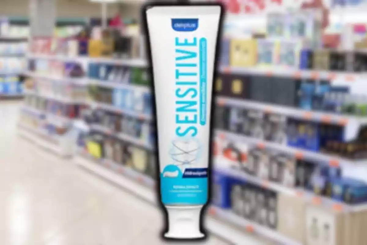 Tubo de pasta de dents Sensitive de la marca Deliplus en un passadís de supermercat desenfocat Tubo de pasta de dents Sensitive de la marca Deliplus en un passadís de supermercat desenfocat
