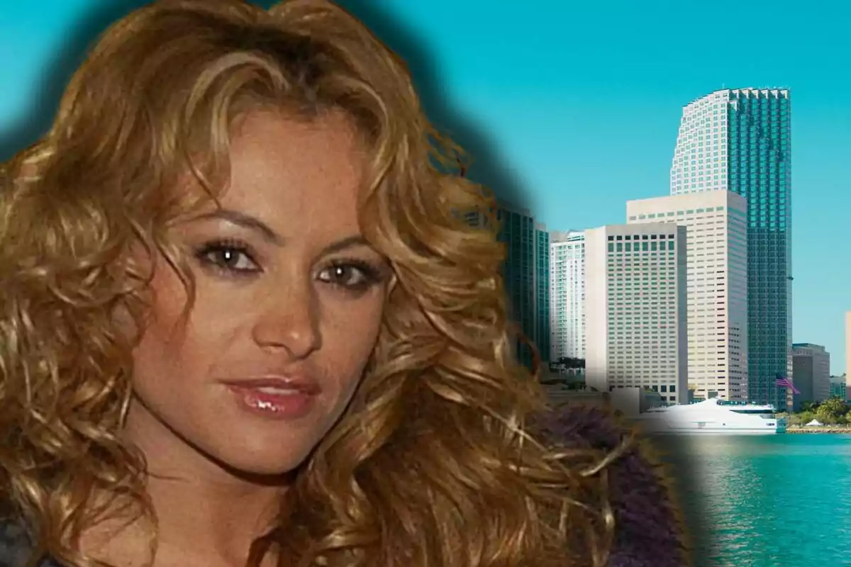 Paulina Rubio en primer pla amb un fons d’edificis moderns al costat d’un cos d’aigua sota un cel blau