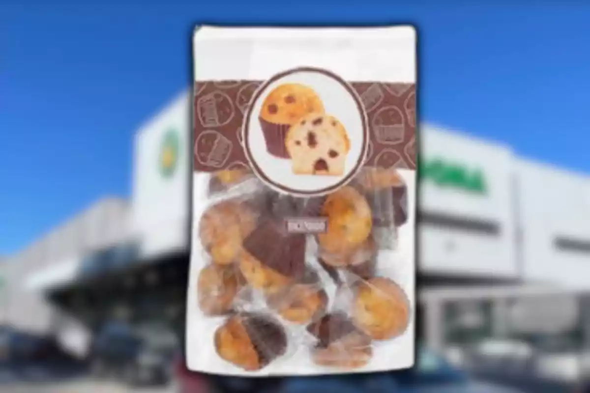 Bossa de mini magdalenes amb xips de xocolata davant d’una botiga desenfocada Bossa de mini magdalenes amb xips de xocolata davant d’una botiga desenfocada