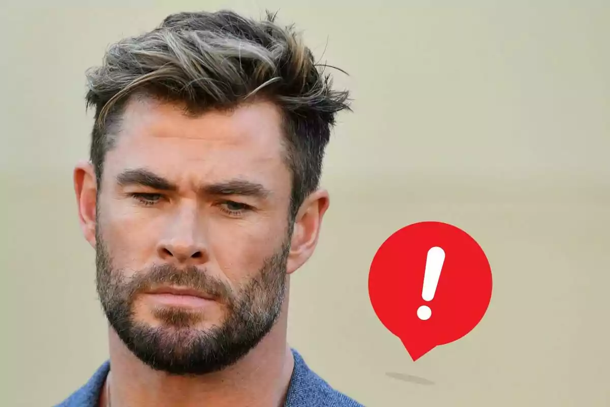 Chris Hemsworth amb expressió seriosa i una icona d'advertència vermella amb un signe d'exclamació al seu costat