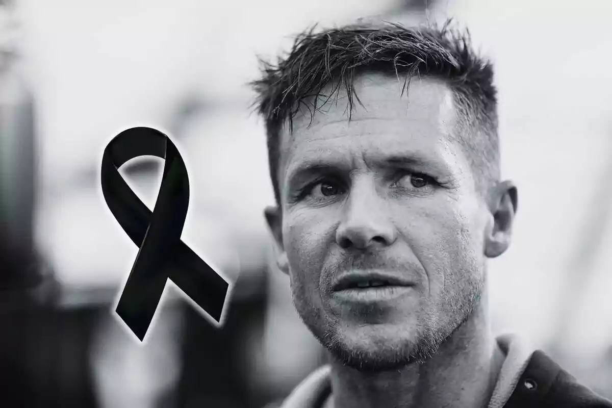 Felix Baumgartner de expresión seria en blanco y negro con un moño negro de luto a la izquierda