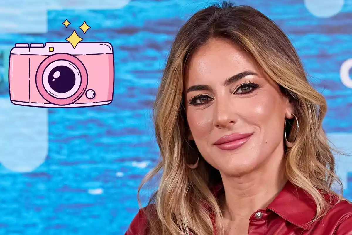 Verónica Dulanto de cabello rubio y ondulado con chaqueta roja posando frente a un fondo azul con una ilustración de cámara rosa a la izquierda