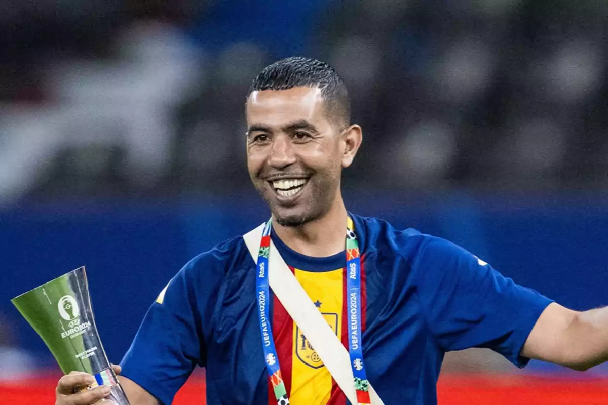 Mounir Nasraoui smiling with a medal and trophy in hand during a sporting event