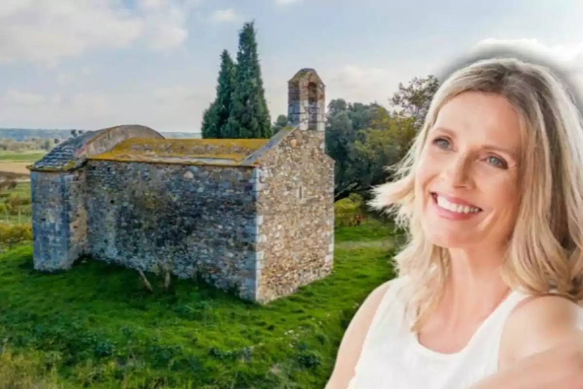 Dona somrient en primer pla amb una petita església de pedra al fons en un entorn rural
