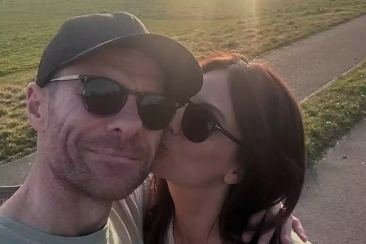 Xabi Alonso i la seva parella fent-se una selfie a l’aire lliure mentre la dona fa un petó a l’home a la galta i tots dos porten ulleres de sol. Xabi Alonso i la seva parella fent-se una selfie a l’aire lliure mentre la dona fa un petó a l’home a la galta i tots dos porten ulleres de sol.