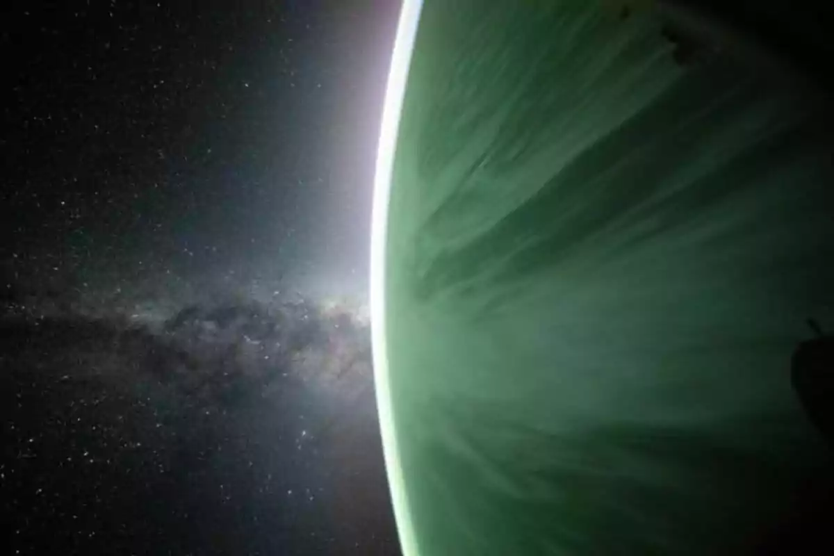 Vista d’un planeta verd amb la seva atmosfera il·luminada i l’espai estrellat de fons Vista d’un planeta verd amb la seva atmosfera il·luminada i l’espai estrellat de fons