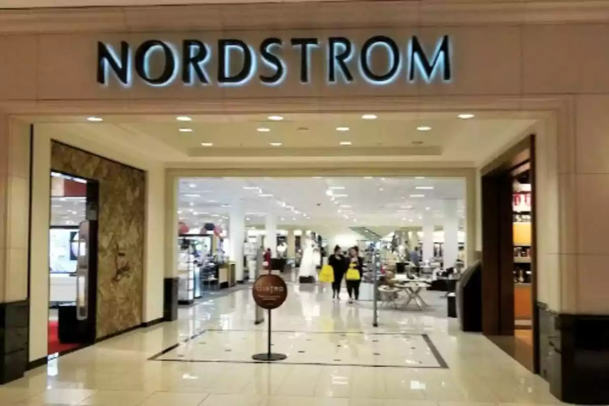 Entrada de una tienda Nordstrom en un centro comercial con personas caminando y bolsas de compras Entrada de una tienda Nordstrom en un centro comercial con personas caminando y bolsas de compras