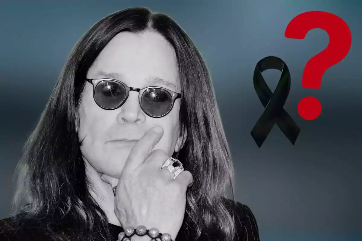 Ozzy Ousbourne amb cabells llargs i ulleres fosques amb expressió pensativa al costat d’un llaç negre i un signe d’interrogació vermell sobre fons blau.