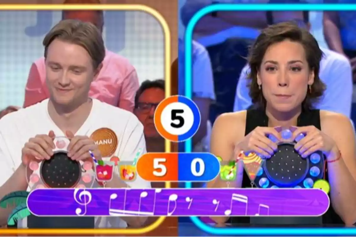 Manu i Rosa participen en un joc de preguntes musicals en un programa de televisió, cadascun sosté un polsador i el marcador mostra una puntuació de cinc a zero. Captura de 'Pasapalabra' Manu i Rosa participen en un joc de preguntes musicals en un programa de televisió, cadascun sosté un polsador i el marcador mostra una puntuació de cinc a zero. Captura de 'Pasapalabra'